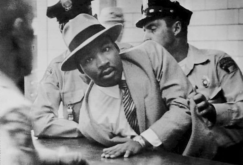 Martin Luther King Jr. being arrested for loitering ("hanging around") while present at a colleague's court case in 1958. 